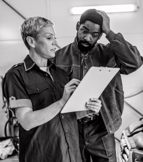 Mechanic showing a stressed-out customer his car bill.